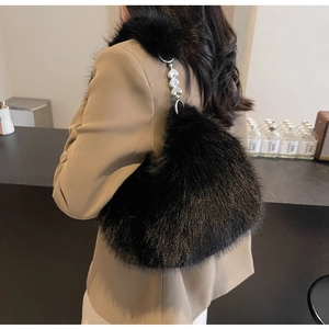 Gros plan du sac bandoulière en fausse fourrure noire avec boucle en métal en forme de cœur