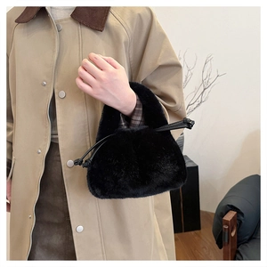 Detail of soft black faux fur bucket bag with leather drawstring and plush texture