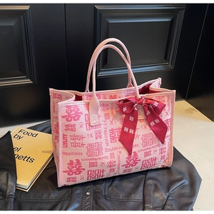 Close-up of pink wedding tote bag with red Double Happiness pattern and silk bow detail