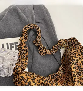 Détail d'un sac léopard tendance avec bandoulière élastique plissée sur tissu