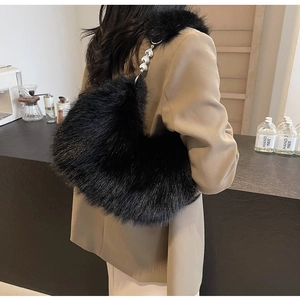 Détail du sac à bandoulière en fausse fourrure noire avec chaîne cœur argentée