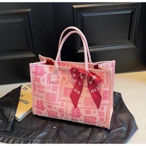 Detail of pink wedding tote bag featuring red Double Happiness prints and a satin bow