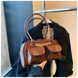 Vue détaillée d'un sac à main en cuir marron foncé brillant avec deux poches
