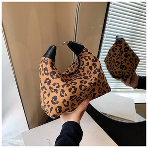 Details einer Handtasche mit Leopardenmuster, schwarzen Lederbesätzen und Metallverschluss