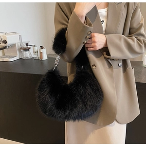 Détail du sac croissant noir en fausse fourrure avec chaîne décorative à cœur argenté