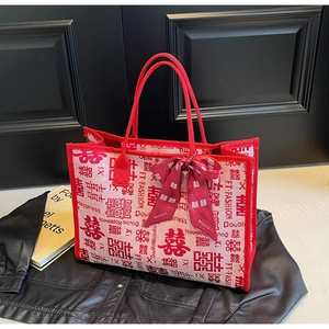 Detail of white bridal tote bag with red Double Happiness prints and satin bow accent