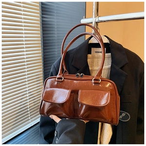 Détail d'un sac à main en cuir marron brillant avec doubles poches à rabat