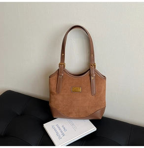 Details der karamellbraunen Wildledertasche mit goldener Schnalle und Glattleder-Nähten