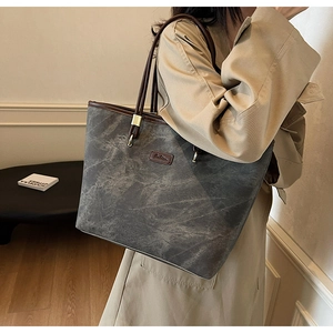 Detail view of washed canvas tote bag with leather handles and fashion leather patch
