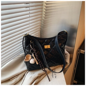 Détail du sac seau noir matelassé avec fermoir doré et accessoire de sac de baseball
