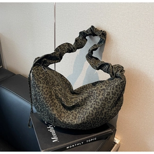 Détail du sac croissant à motif léopard vert olive avec une bandoulière froncée