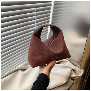 Detailansicht der dunkel rotbraunen Wildlederhandtasche mit geometrischer Dreiecksform