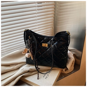 Détail du sac hobo matelassé noir avec fermoir doré et pendentif de sac de baseball