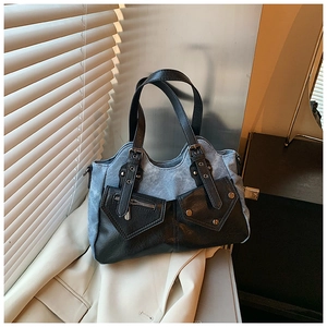 Detail der Color-Block-Tasche mit blauem Canvas, schwarzem Leder und Metall-Zippern