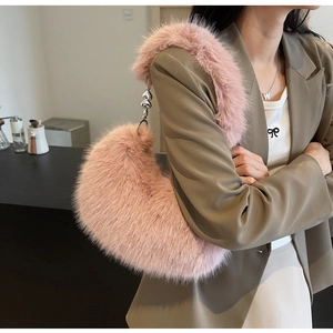 Gros plan détaillé du sac croissant en fausse fourrure rose avec pendentif en cœur