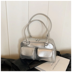 Détail du sac à main argenté texturé avec doubles poches frontales et finition métallique