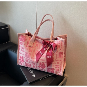 Detailed side view of pink wedding tote bag with silk bow and double happiness patterns