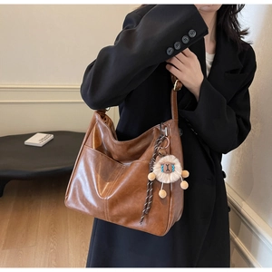 Brown vintage faux leather tote bag with front pocket and plush lamb charm detail
