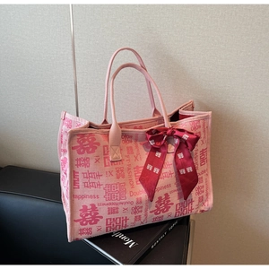 Detail of pink bridal tote bag with red Double Happiness prints and a silk bow ribbon