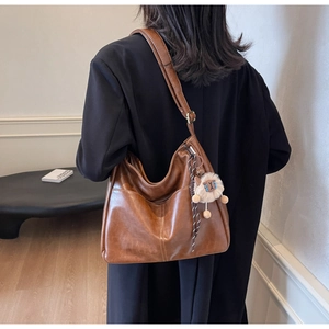 Detailed view of the brown vintage large hobo bag with adjustable strap and cute plush charm