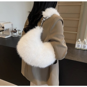 Détail d'un sac hobo en fausse fourrure blanche avec chaîne argentée et cœur