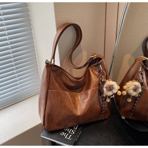 Detailed macro of brown retro PU leather tote bag with a small plush sheep charm
