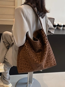 Chic leopard print tote bag with suede texture shown on shoulder for versatile style