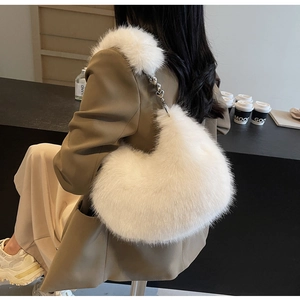 Détail du sac hobo en fausse fourrure blanche avec texture pelucheuse et boucle cœur