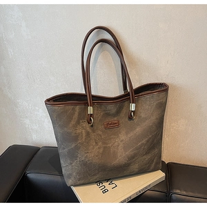 Detail of vintage canvas tote bag with brown leather trim and fashion brand label