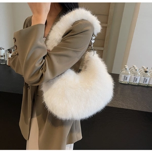 Détail du sac hobo en fausse fourrure blanche avec chaîne argentée et breloque cœur