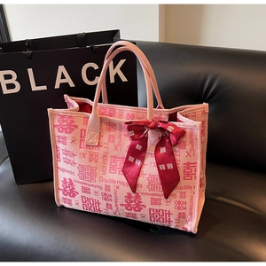 Close-up of pink canvas wedding tote bag with red Double Happiness prints and velvet bow