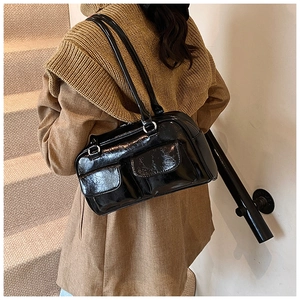 Vue détaillée du sac à bandoulière noir brillant avec poches avant et boucles en métal