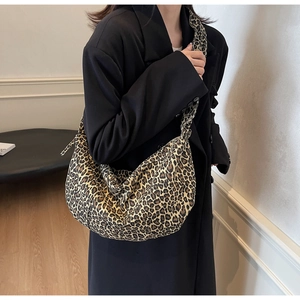 Détail du sac croissant à imprimé léopard avec large bandoulière porté par un mannequin