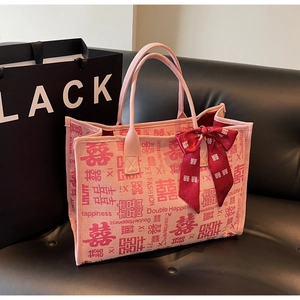 Close-up of pink wedding tote bag with red Double Happiness prints and silk bow detail