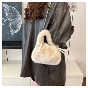 Detail of plush faux fur bucket bag with golden chain strap and drawstring closure