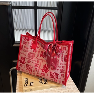 Macro shot of red double happiness wedding tote bag with silk ribbon on a stone surface