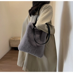 Sac fourre-tout en fausse fourrure grise porté par un mannequin pour l'effet de style
