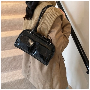 Vue détaillée du sac bandoulière en cuir verni noir avec poches et boucles en métal argenté