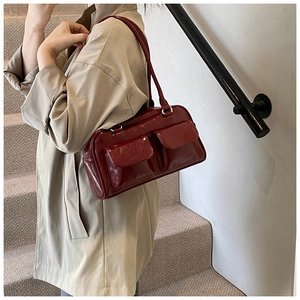 Sac bandoulière rouge foncé en cuir verni avec texture plissée et poches frontales