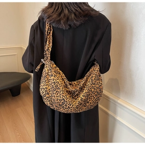Détail de la bandoulière large d'un sac bandoulière en forme de croissant à motif léopard