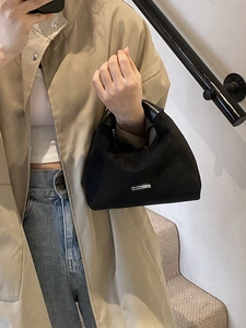 Minimalistische schwarze Halbmond-Handtasche mit silbernem Logo-Schild im City-Stil