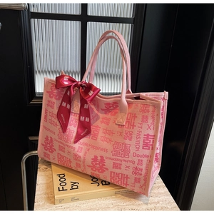 Detail of pink wedding tote bag with red Double Happiness embroidery and silk ribbon bow