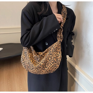 Sac bandoulière tendance à imprimé léopard porté sur un manteau en laine noir
