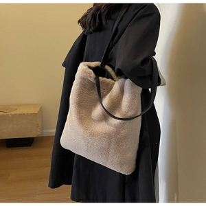 Détail de la texture d'un cabas en fausse fourrure beige avec fines bretelles en cuir