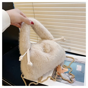 Detail of soft beige plush handbag with leather drawstring and elegant gold chain strap