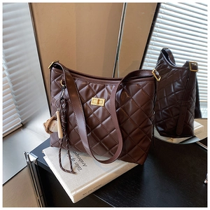 Détail du sac hobo matelassé marron foncé avec fermoir doré et porte-clés