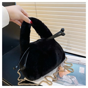 Detail of black faux fur handbag featuring gold chain strap and side knot accents