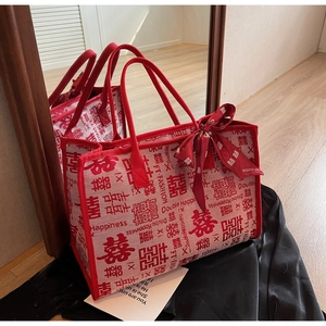 Macro detail of red bridal tote bag with Xi characters and silk ribbon decoration