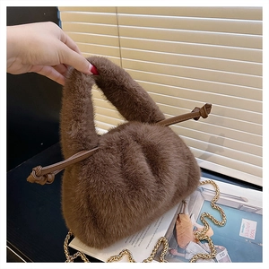 Detail view of dark brown plush bucket bag featuring soft faux fur and knotted handle