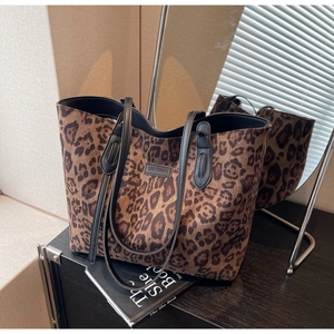 Detail of leopard print tote bag fabric texture with black leather logo patch